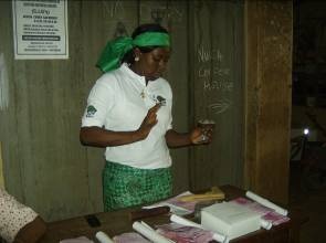 A Community Volunteer carries out condom demonstrations on Women's Day 2011